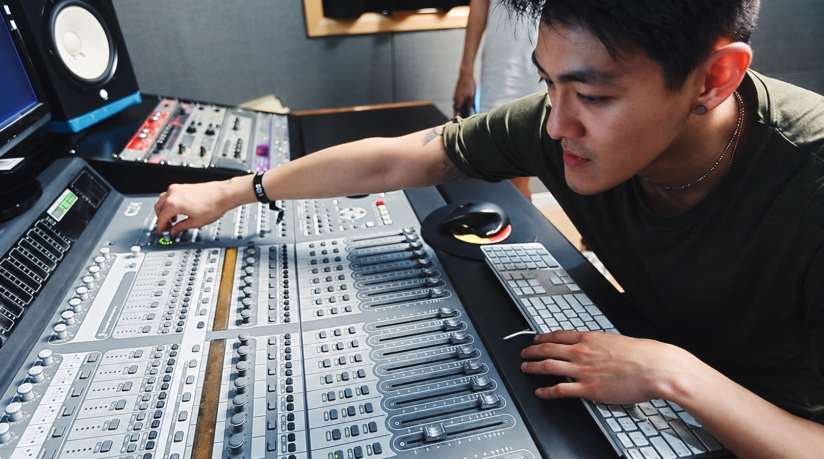 Stanley Yang working at the audio control board in a music studio